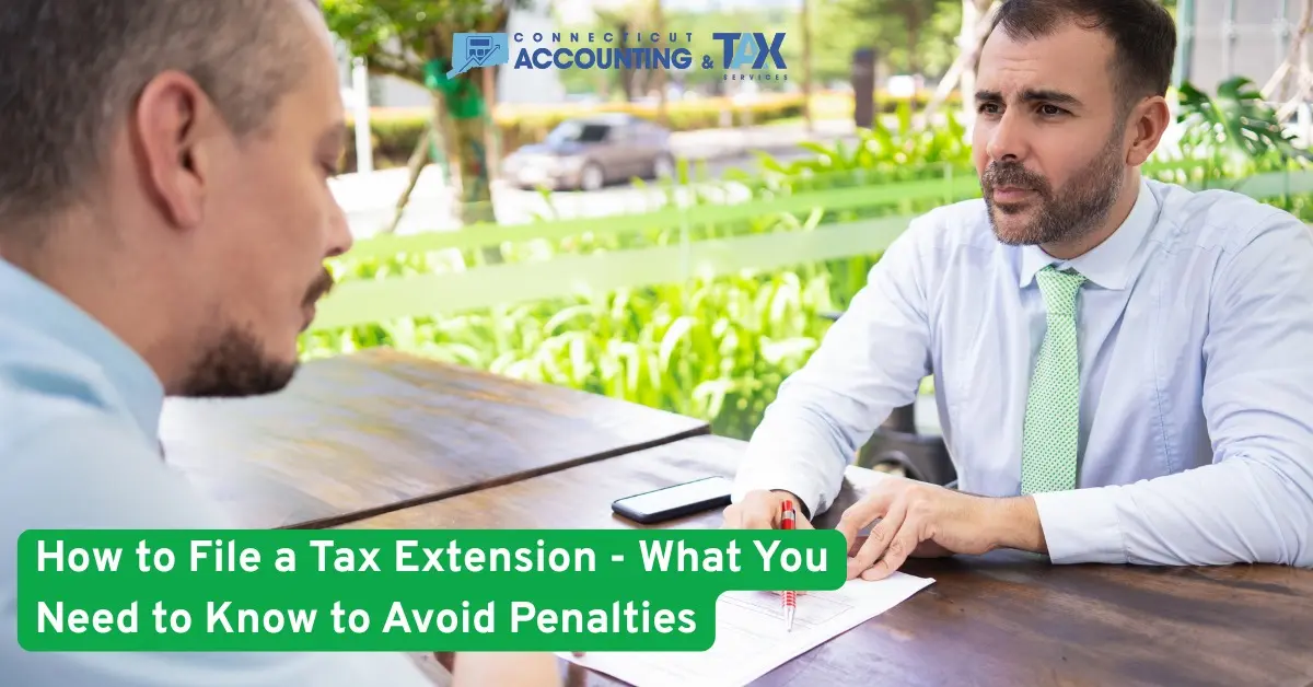 Two men discussing tax documents at an outdoor table with text overlay: How to File a Tax Extension and Avoid Penalties