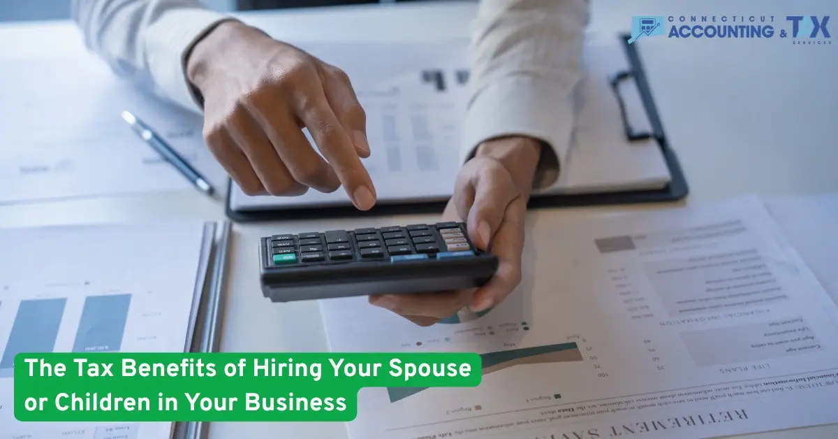 Business person using a calculator and reviewing financial documents to analyze tax savings and benefits of hiring family in a small business.