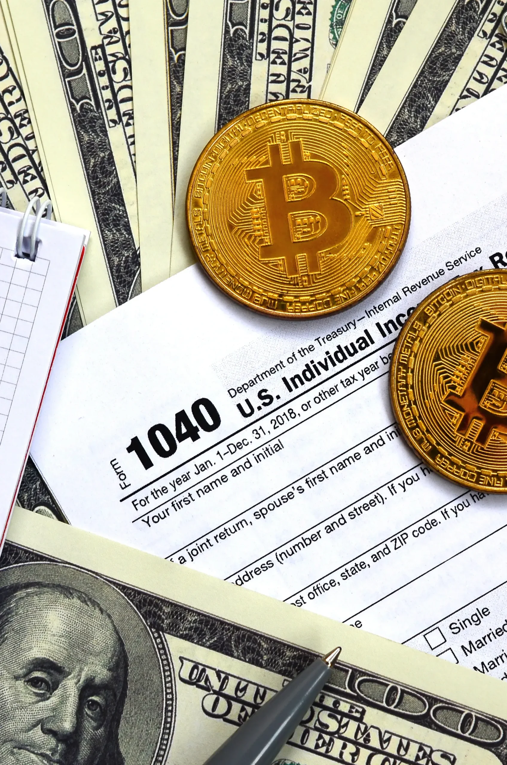 Bitcoin coins placed on IRS Form 1040 with US dollar bills, highlighting crypto tax reporting, digital assets, and income filing requirements